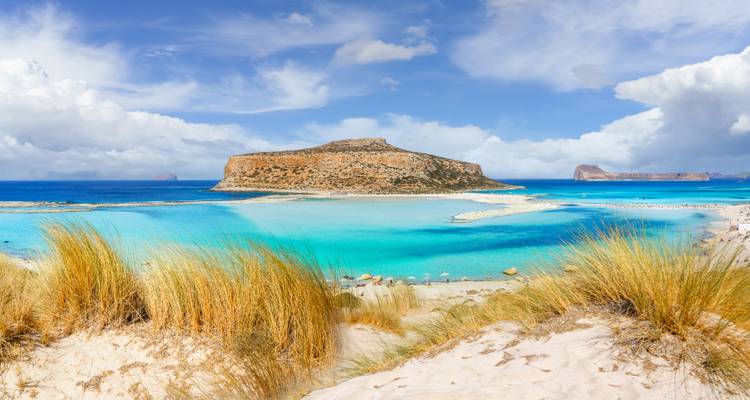 Scenic coastal landscape with turquoise waters and sandy dunes.