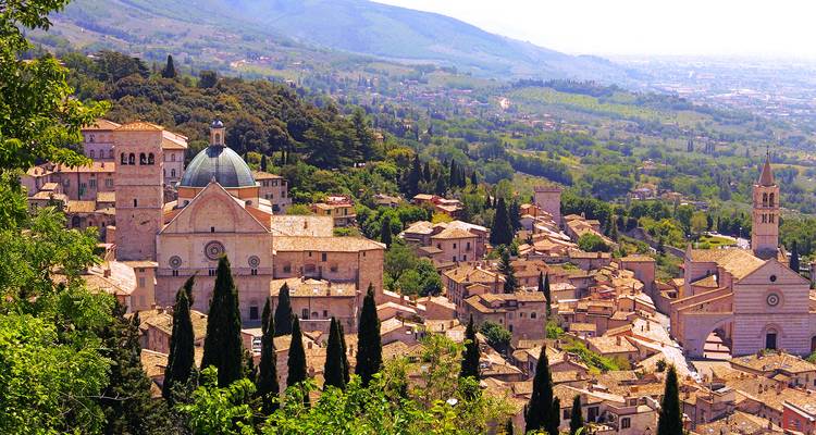 The medieval hill town of Assisi spreads below green ridges crowned by basilicas and towers.