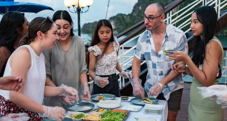 Des amis savourant un repas ensemble sur un bateau avec un décor pittoresque.