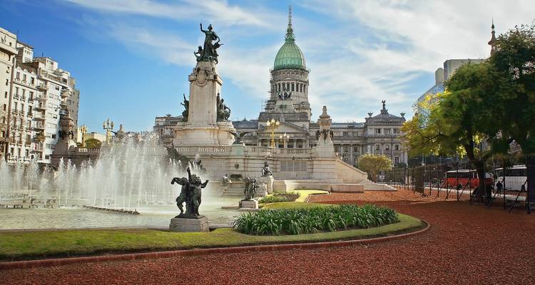 Fontaine et statues ornées devant le bâtiment du Congrès national d'Argentine sous un ciel bleu.