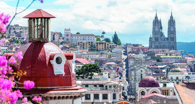 Blick auf Quito mit markanten Kirchen und Bergen.