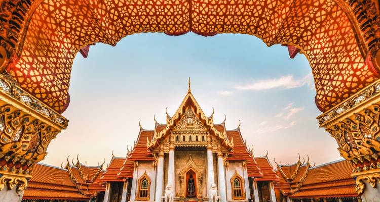 Sierlijke tempel met gouden architectuur en blauwe lucht.