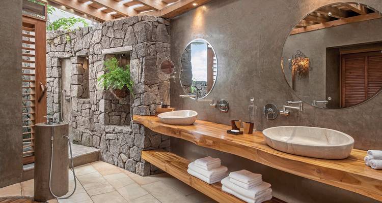 Elegant bathroom with stone walls and twin sinks.