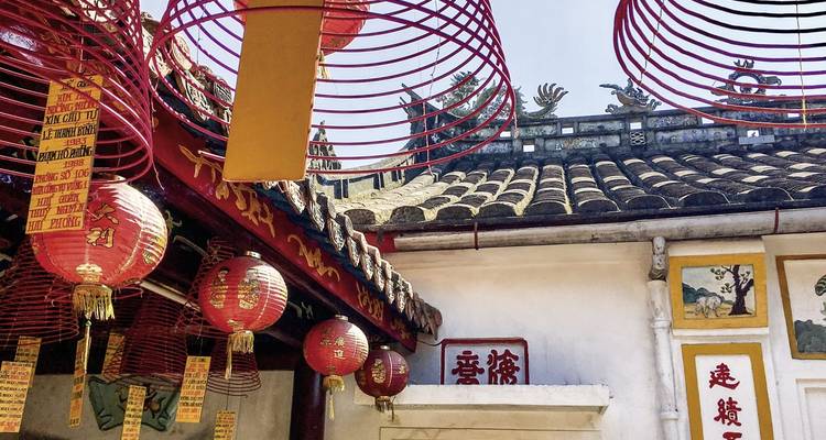 Decorative red lanterns and incense coils in a temple setting.