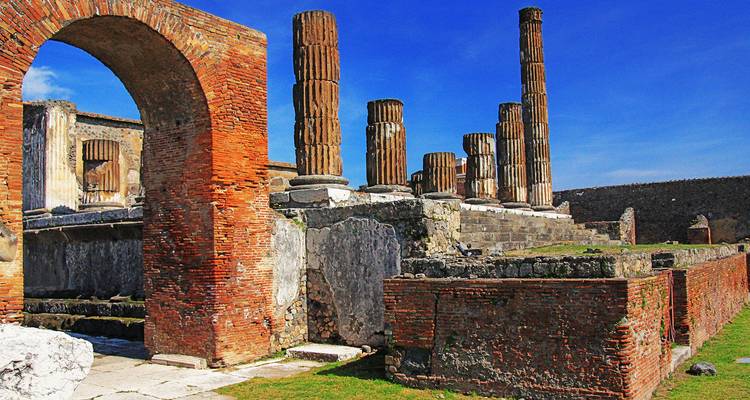 Verwoeste bakstenen zuilen en bogen van het antieke Pompeii die glanzen onder de heldere hemel.