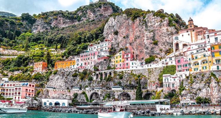 Kleurrijke gebouwen van Amalfi op spectaculaire rotsen boven smaragdgroene Mediterranean wateren.