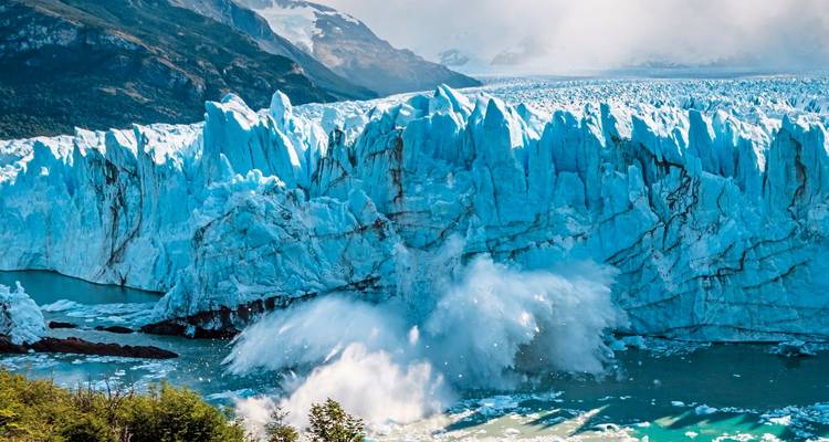Massive blaue Wand des Perito-Moreno-Gletschers bricht ins Wasser ab und sendet dramatische Wasserfontänen auf