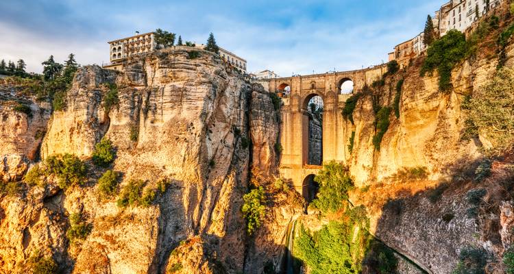 Vue d'un pont historique au-dessus d'une gorge profonde avec des bâtiments au-dessus.