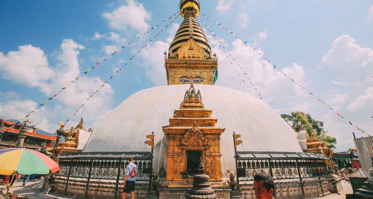 Stupa de Swayambhunath con banderas de oración y gente.