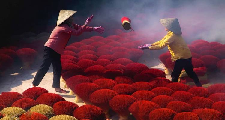 Dos personas jugando con varillas de incienso rojo brillante.