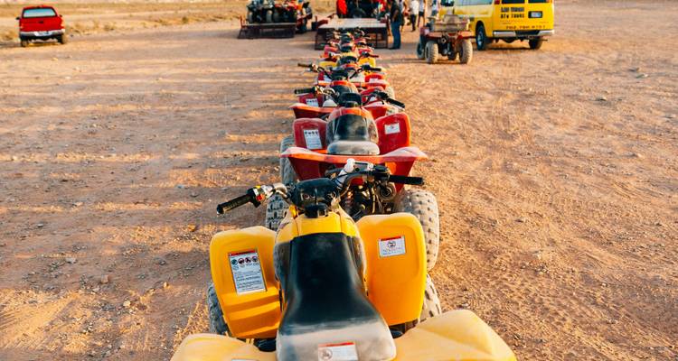 Ligne de VTT garés sur un terrain sablonneux.