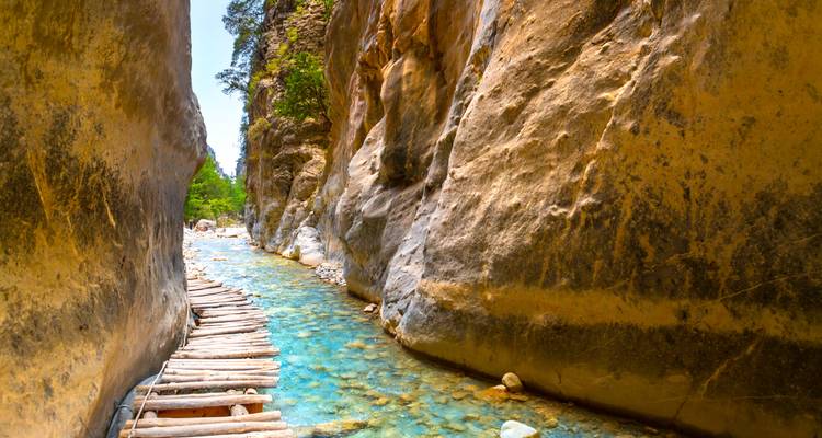 Narrow river canyon with a wooden walkway.