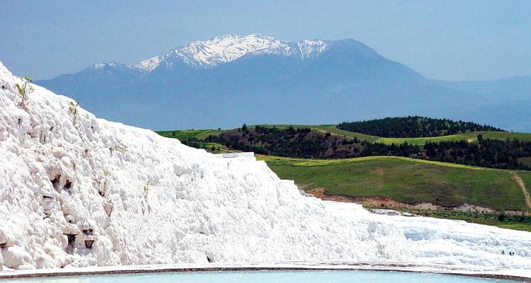 Pamukkale travertine terraces with a distant mountain.