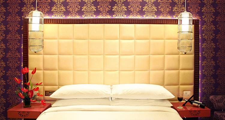 Intérieur de chambre d'hôtel de luxe avec mur décoratif et éclairages.