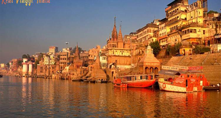 Riverside view of historic city buildings reflecting on water.