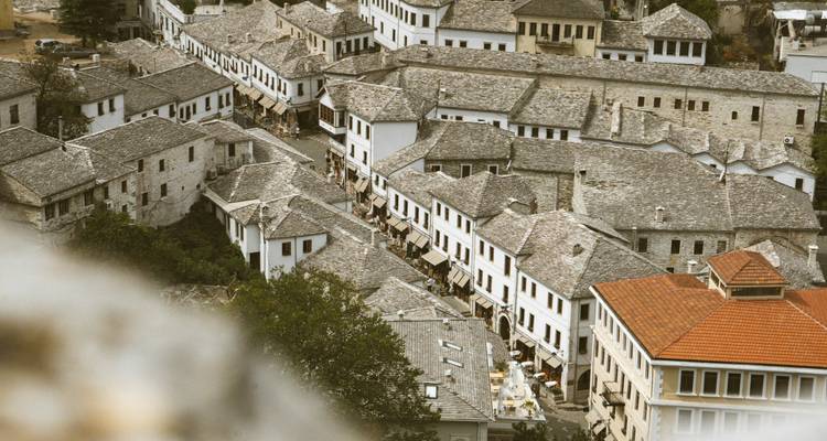 Vue aérienne de maisons ottomanes aux toits de pierre densément serrées le long d'une étroite rue de bazar dans une ville historique de colline.
