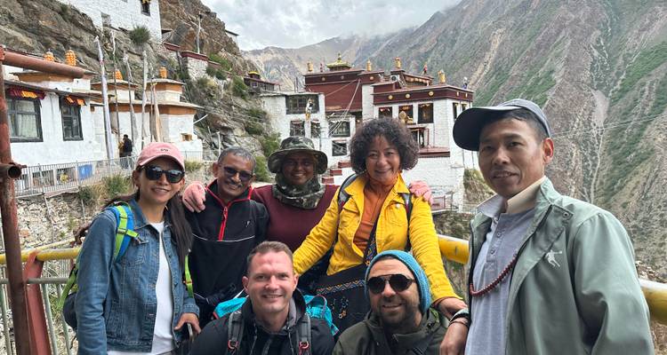 Photo de groupe devant des bâtiments traditionnels à flanc de montagne.