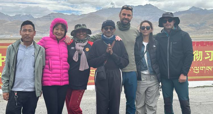 Groupe de voyageurs posant avec un paysage montagneux en arrière-plan.