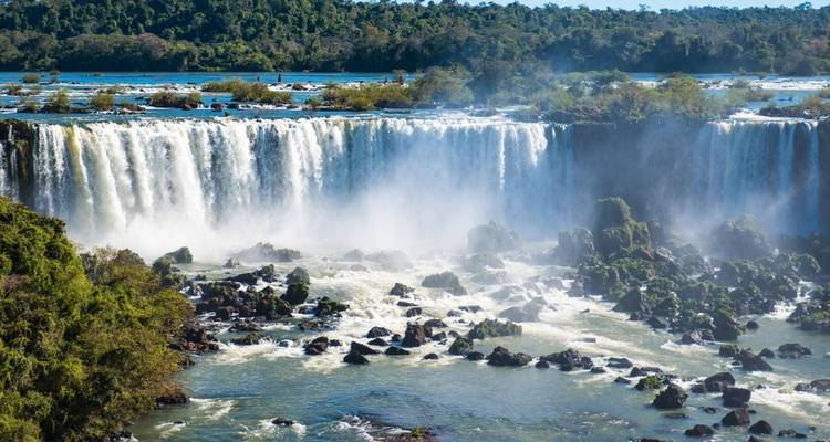 Distant view of wide waterfalls in a river setting.