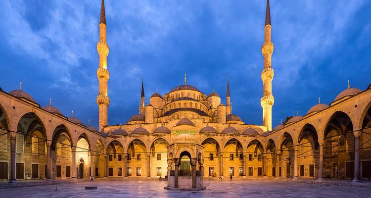 Innenraum einer großen Moschee mit verziertem Dach.