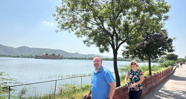 Couple se promenant au bord d'un lac avec le Jal Mahal à Jaipur.