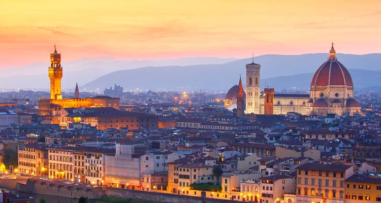 Vue de Florence au coucher du soleil avec des cathédrales emblématiques et un ciel vibrant.