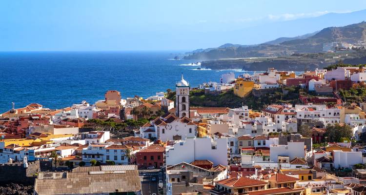A coastal Canarian town with terracotta roofs and church tower overlooks the deep blue Atlantic.