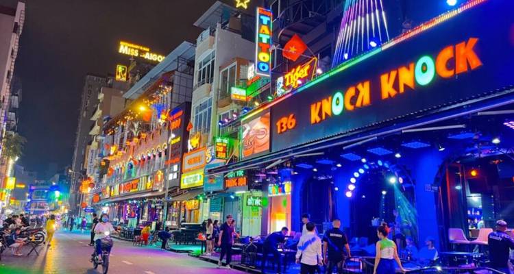 Vibrant nightlife street scene with neon lights.