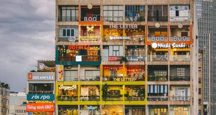 Exterior of a building with multiple colorful storefronts.