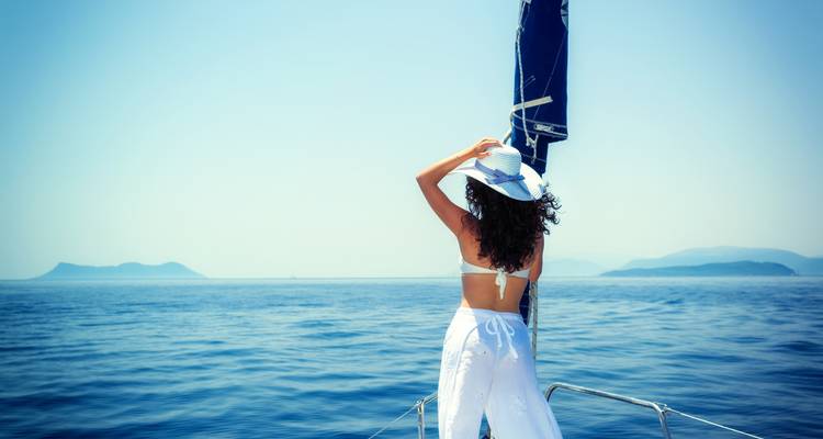 Frau auf einem Boot, die zum Meer blickt.
