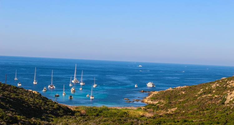 Una bahía tranquila con veleros y un mar azul cristalino