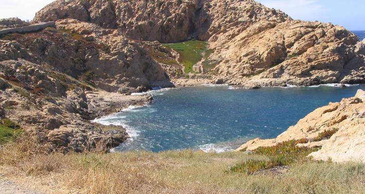 Costa rocosa con una pequeña bahía y mar azul cristalino