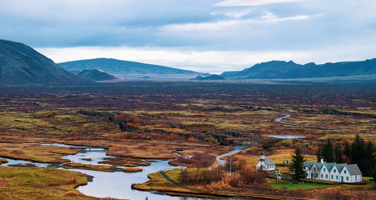 Paysage expansif avec une rivière entourée de collines.