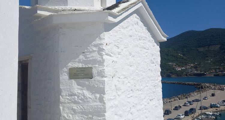 Edificio blanco con vista al puerto y las montañas.