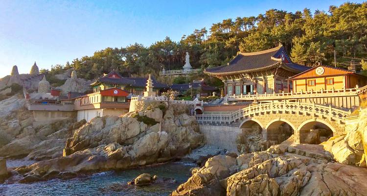 Complexe de temples en bord de mer avec architecture coréenne traditionnelle et paysage rocheux.