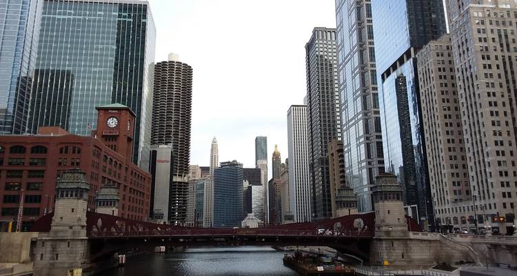 Horizon de Chicago avec un pont au-dessus d'une rivière calme.