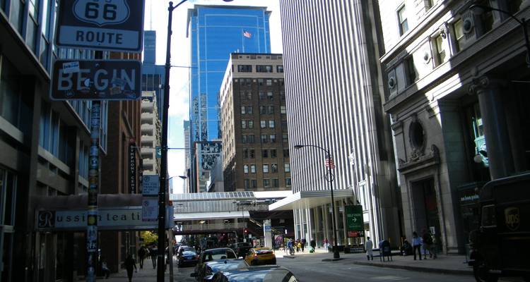Rue urbaine avec des immeubles de grande hauteur et signalisation de la Route 66.