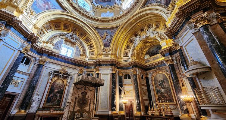 Intérieur somptueux doré et marbré d'une chapelle royale avec des dômes élancés, des fresques et des lustres.