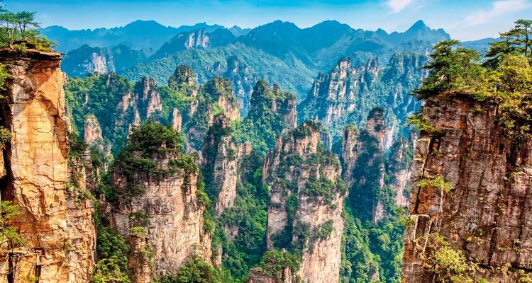 Dramatic sandstone pillars in a forested landscape.