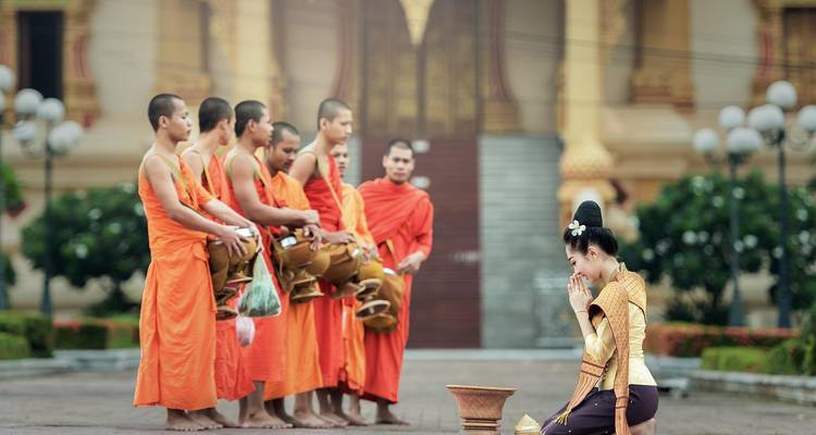 Groep monniken die offerandes ontvangen.
