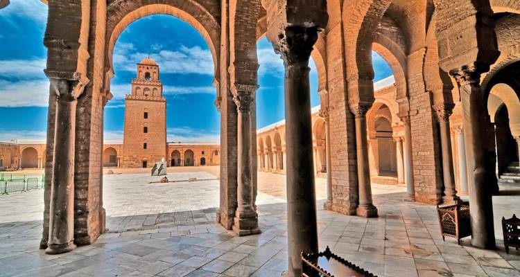 Interior view of the Great Mosque of Kairouan with arches and minaret.