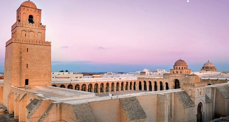 The Great Mosque of Kairouan during sunset with pink sky.