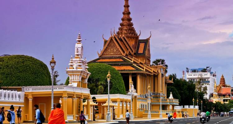 Ornate temple with people and a sunset sky.
