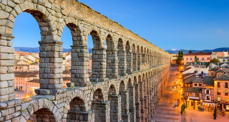 Aqueduc ancien avec une vue sur le paysage urbain en arrière-plan.