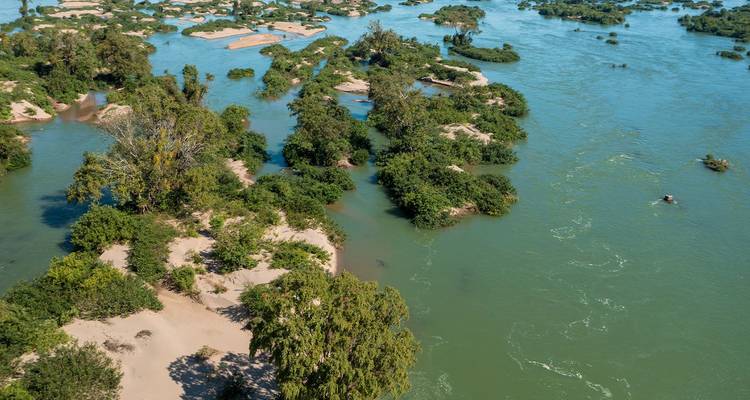 Vista aérea de islas verdes y bancos de arena dispersos en un amplio río tropical