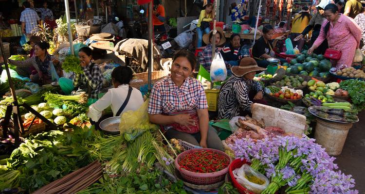 A lively market scene with people selling fresh produce.