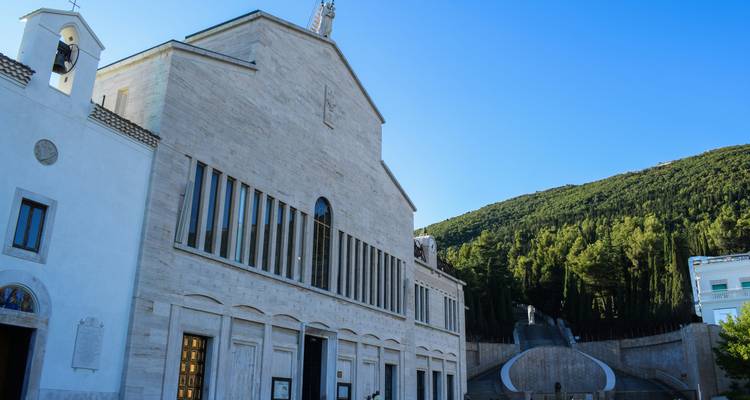 A modern church surrounded by greenery.