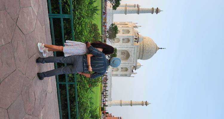 Couple s'embrassant avec le Taj Mahal en arrière-plan.