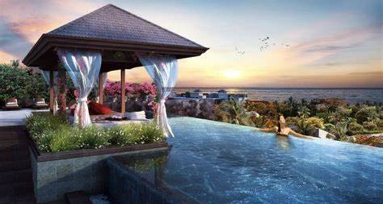 Eine luxuriöse Poolhütte mit Blick auf das Meer bei Sonnenuntergang.