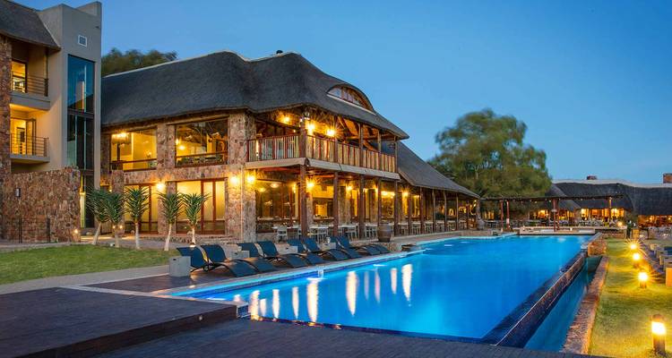 Un entorno lujoso junto a la piscina en un albergue durante la puesta del sol.